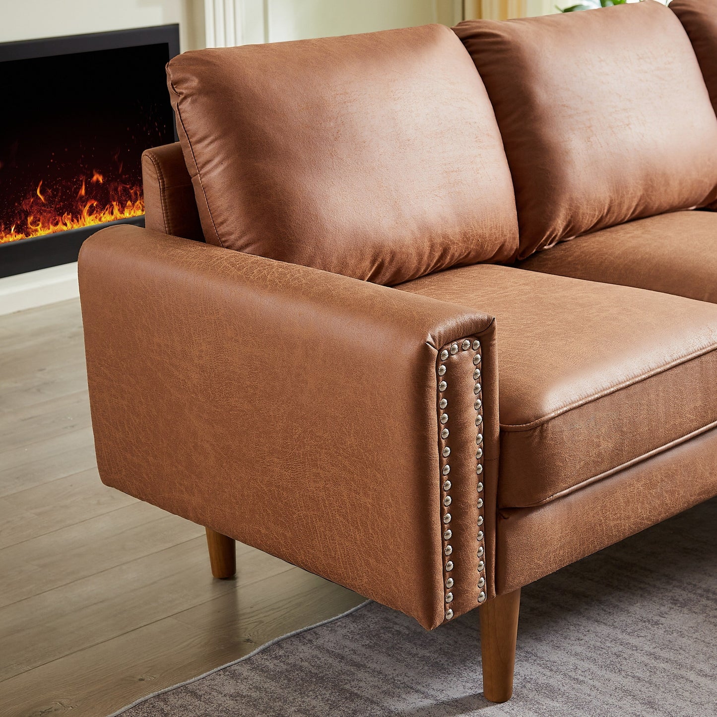 Canapé 3 places en L en cuir synthétique marron de 208 cm avec méridienne gauche et clous décoratifs, finitions cuivrées et pieds en bois massif.