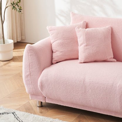 Un canapé rose en polaire de 86,6 pouces avec quatre coussins et des pieds en quincaillerie peut s'asseoir confortablement dans une chambre d'appartement