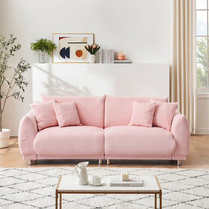 Un canapé rose en polaire de 86,6 pouces avec quatre coussins et des pieds en quincaillerie peut s'asseoir confortablement dans une chambre d'appartement