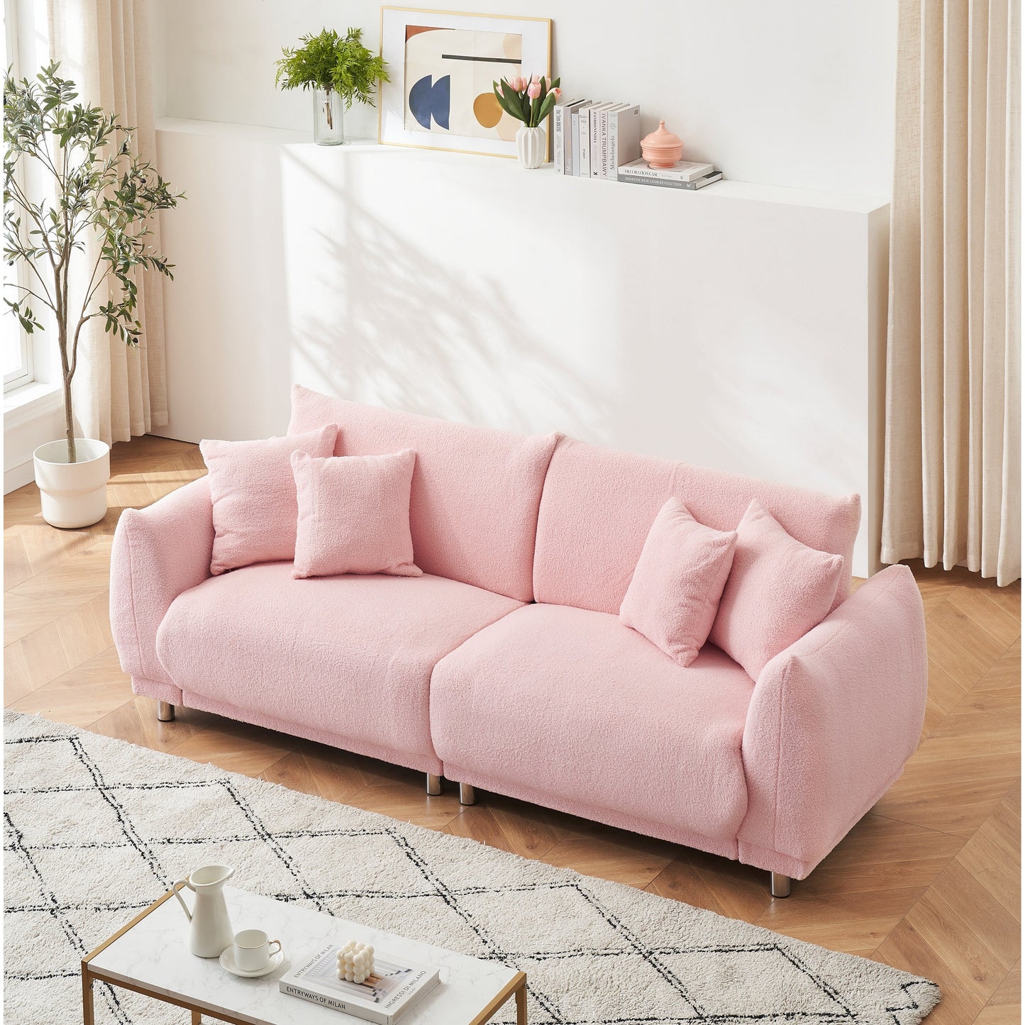 Un canapé rose en polaire de 86,6 pouces avec quatre coussins et des pieds en quincaillerie peut s'asseoir confortablement dans une chambre d'appartement