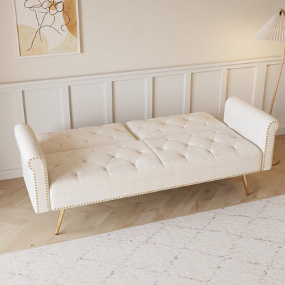 Un canapé-lit de 176 cm de long recouvert de velours, orné d'une bordure cloutée et accompagné d'un coussin assorti.