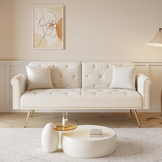 Un canapé-lit de 176 cm de long recouvert de velours, orné d'une bordure cloutée et accompagné d'un coussin assorti.