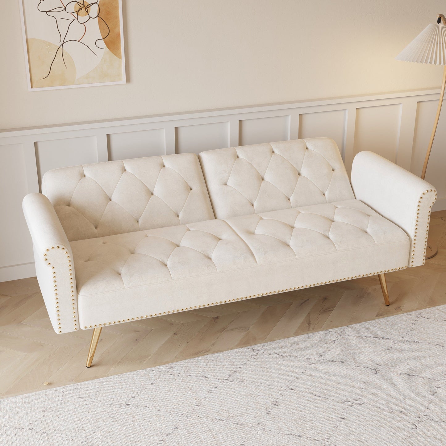 Un canapé-lit de 176 cm de long recouvert de velours, orné d'une bordure cloutée et accompagné d'un coussin assorti.