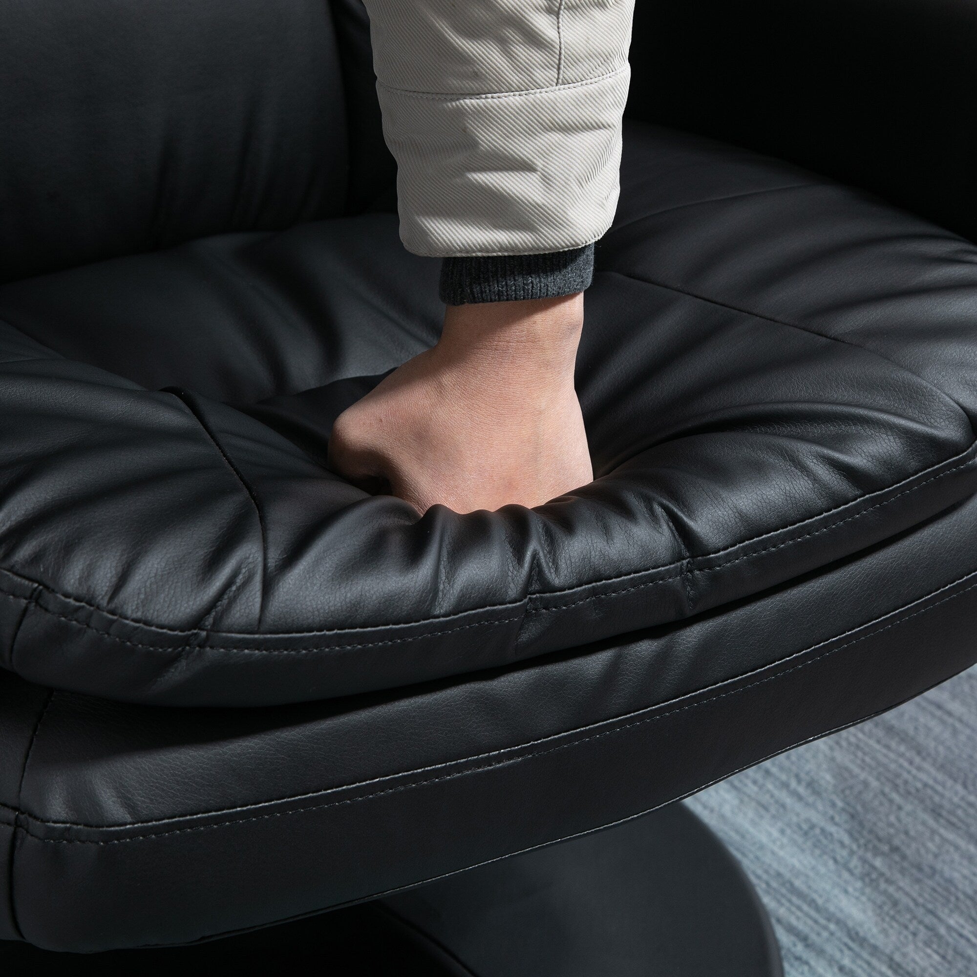 Fauteuil inclinable en cuir synthétique noir avec repose-pieds, dossier réglable et base pivotante