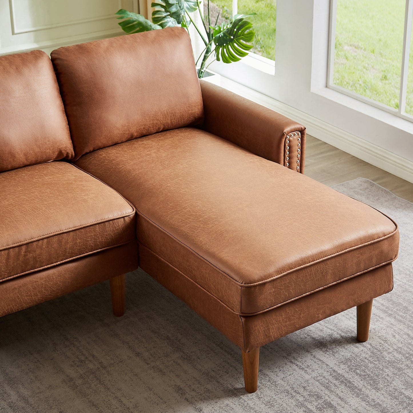 Canapé 3 places en L en cuir synthétique marron de 208 cm avec méridienne gauche et clous décoratifs, finitions cuivrées et pieds en bois massif.
