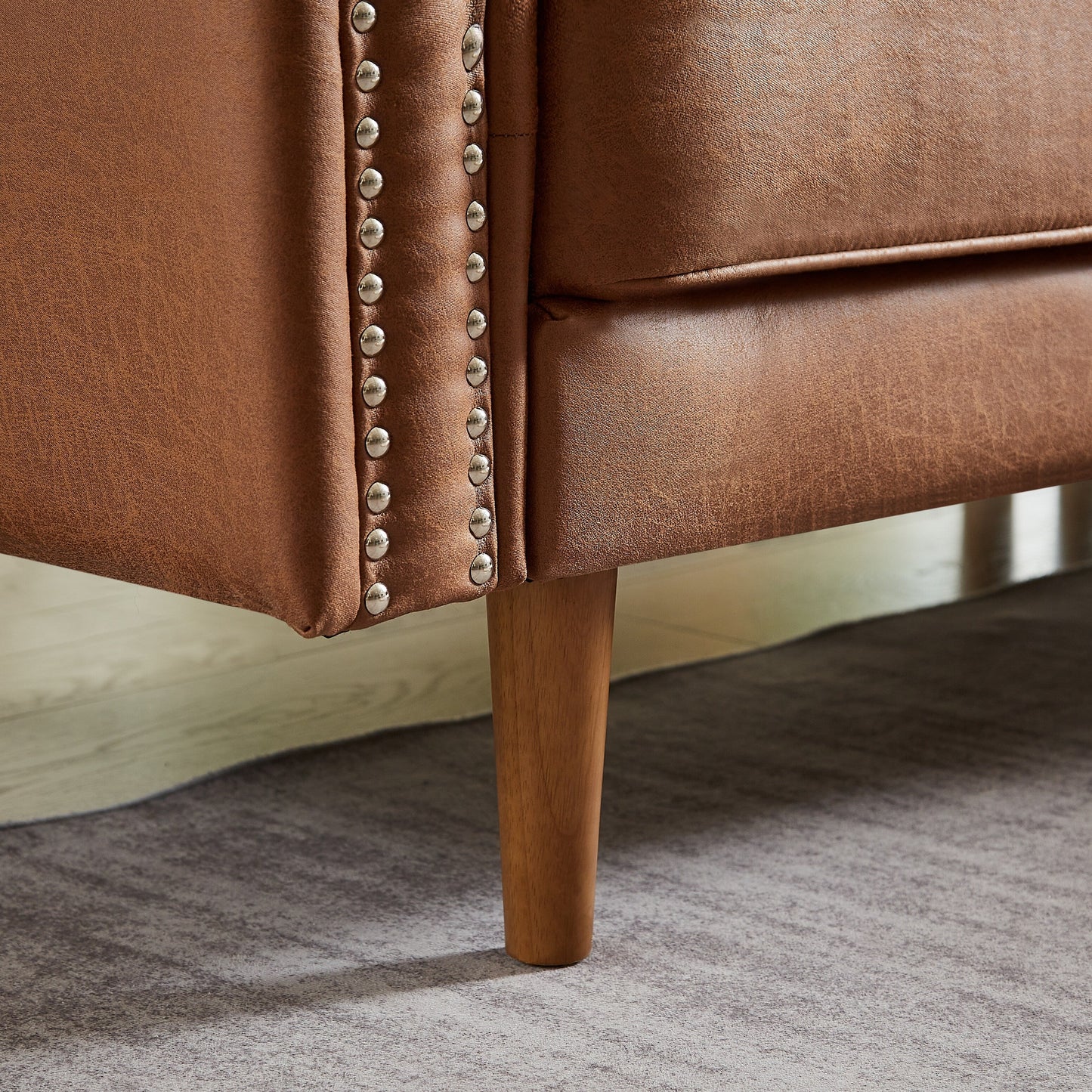 Canapé 3 places en L en cuir synthétique marron de 208 cm avec méridienne gauche et clous décoratifs, finitions cuivrées et pieds en bois massif.