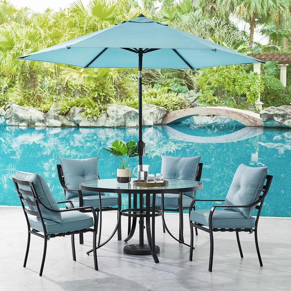 Ensemble de salle à manger Hanover Lavallette 5 pièces bleu océan avec 4 chaises fixes, une table ronde en verre de 132 cm, un parasol et un socle.